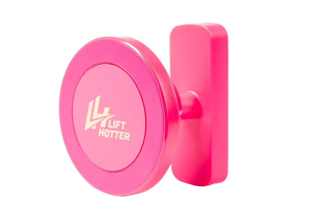 Lift Hotter magnetic gym phone mount in signature pink — front view showing circular disk face with gold LH logo and wall plate