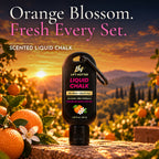 Lift Hotter orange blossom scented liquid chalk bottle in an orange grove at sunset with fresh oranges and blossoms